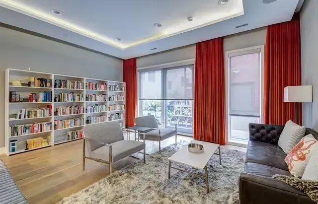 A living room with a couch , chairs , coffee table and bookshelves. Love is Blinds Michigan