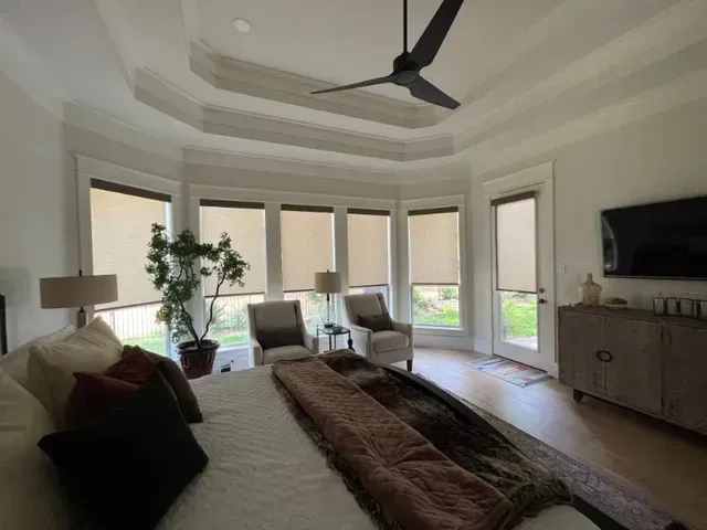A bedroom with a bed , chairs , a television and a ceiling fan. Love is Blinds Arizona (844) 936-2446