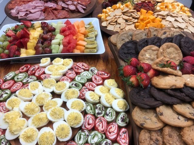 Assorted desserts and fruit platters arranged on a table, including pastries, cookies, and sliced strawberries.