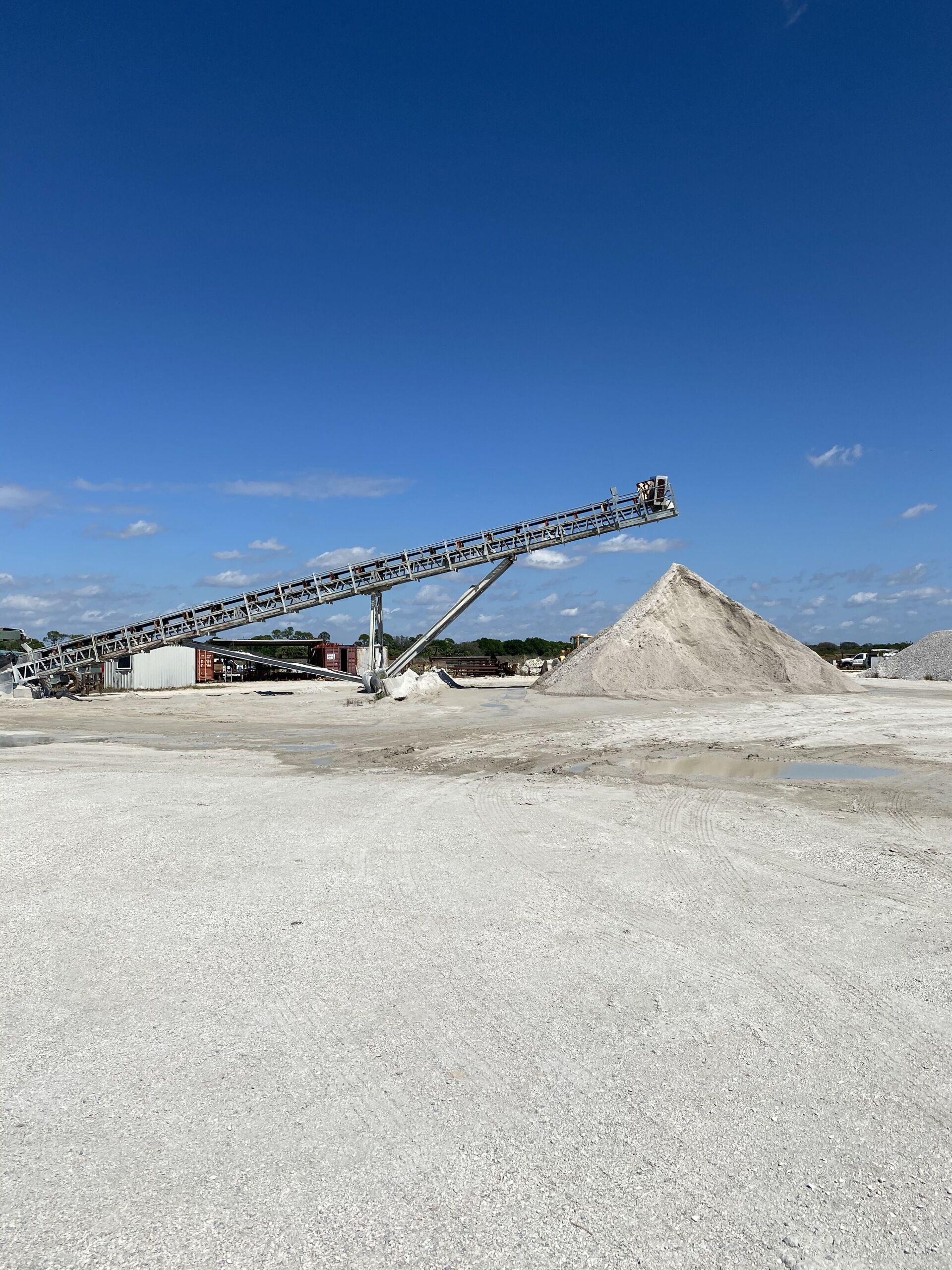 Industrial conveyor at a gravel pit under a clear blue sky