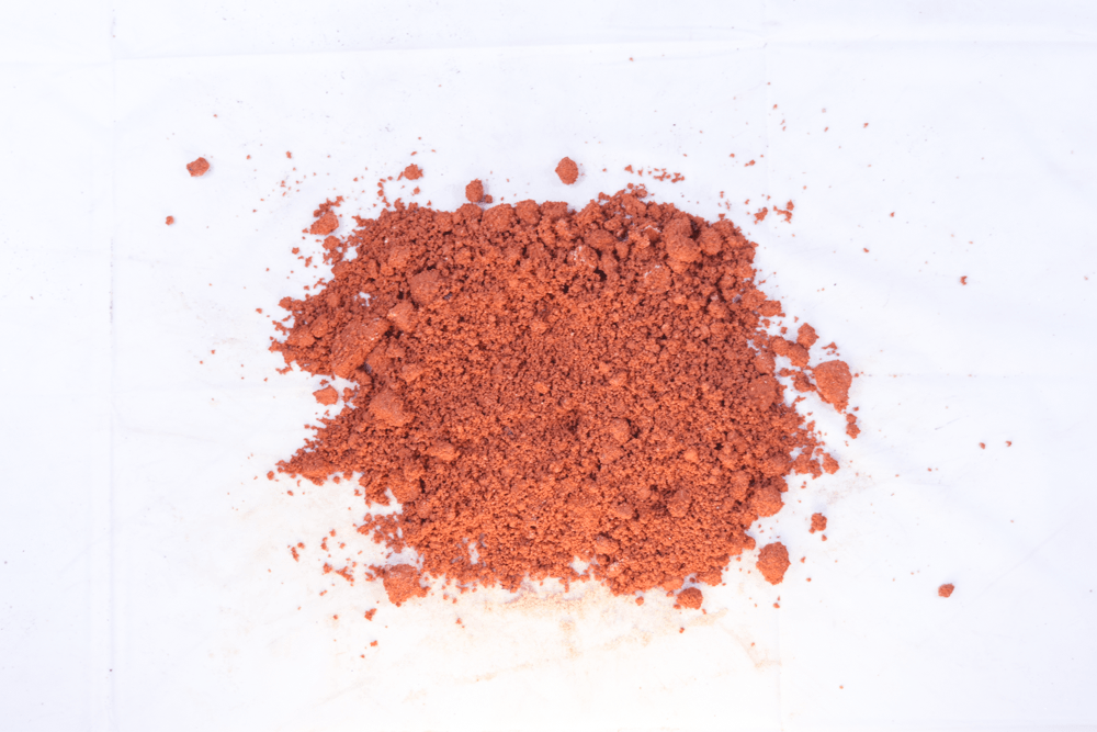 Pile of orange-brown powder on a white background