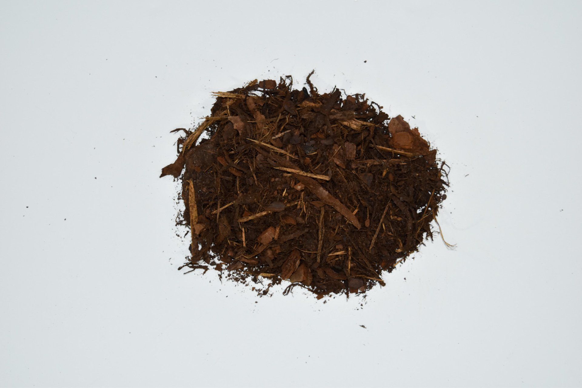 Pile of brown mulch on a white background