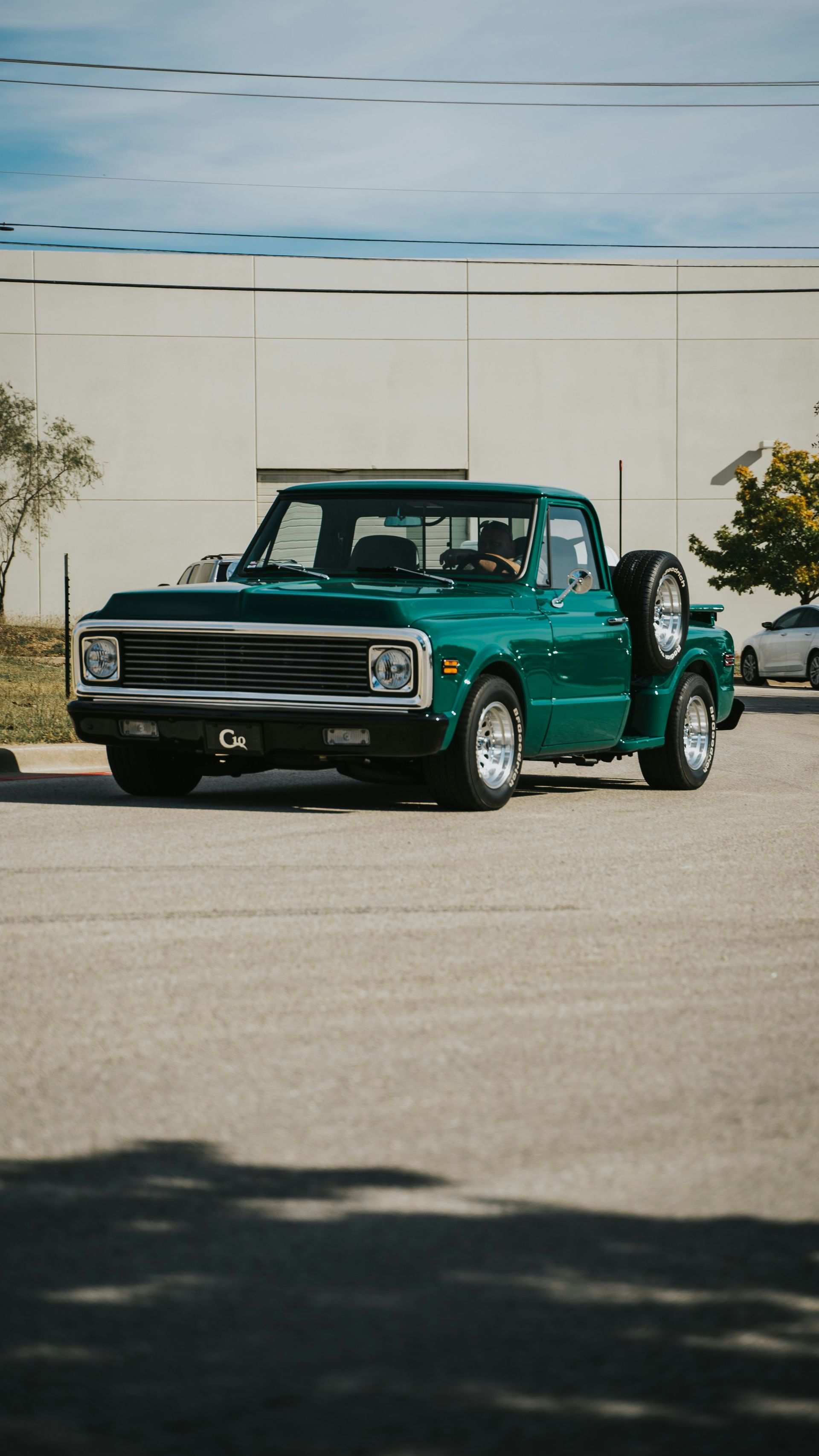 Green vintage Chevrolet truck parked on asphalt.