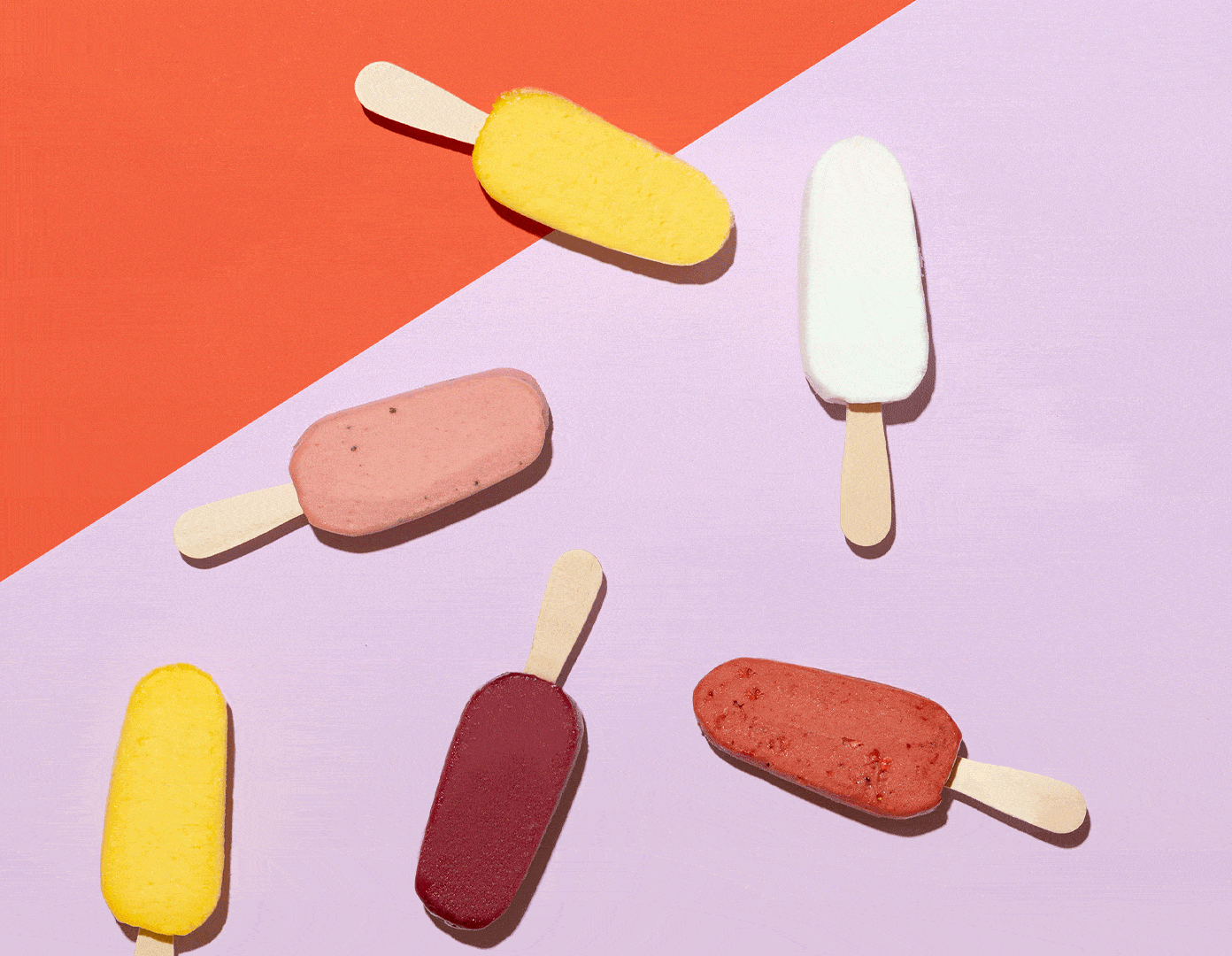 There are many different flavors of ice cream on a pink and red background.