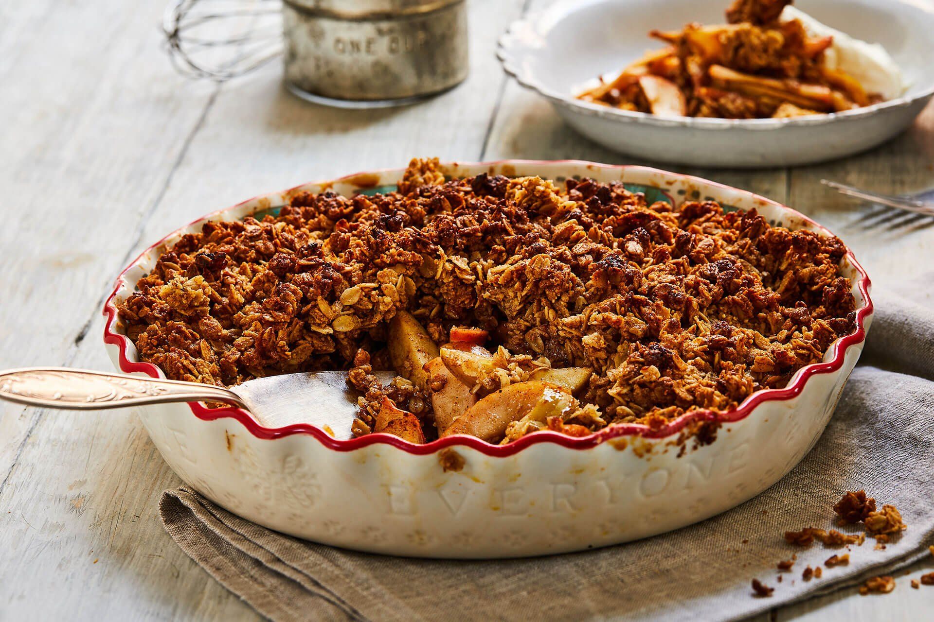 A pie with a spoon in it is sitting on a table.