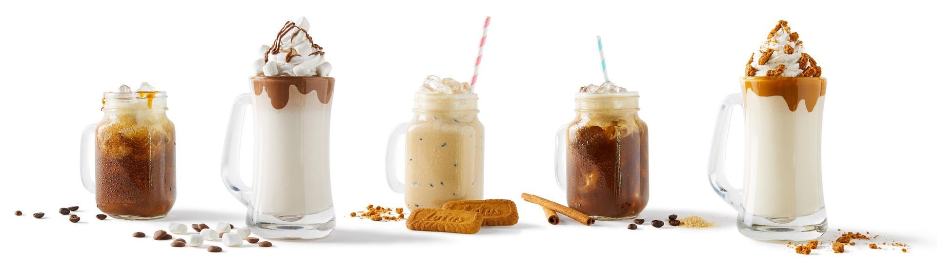 A row of milkshakes in mason jars with straws on a white background.
