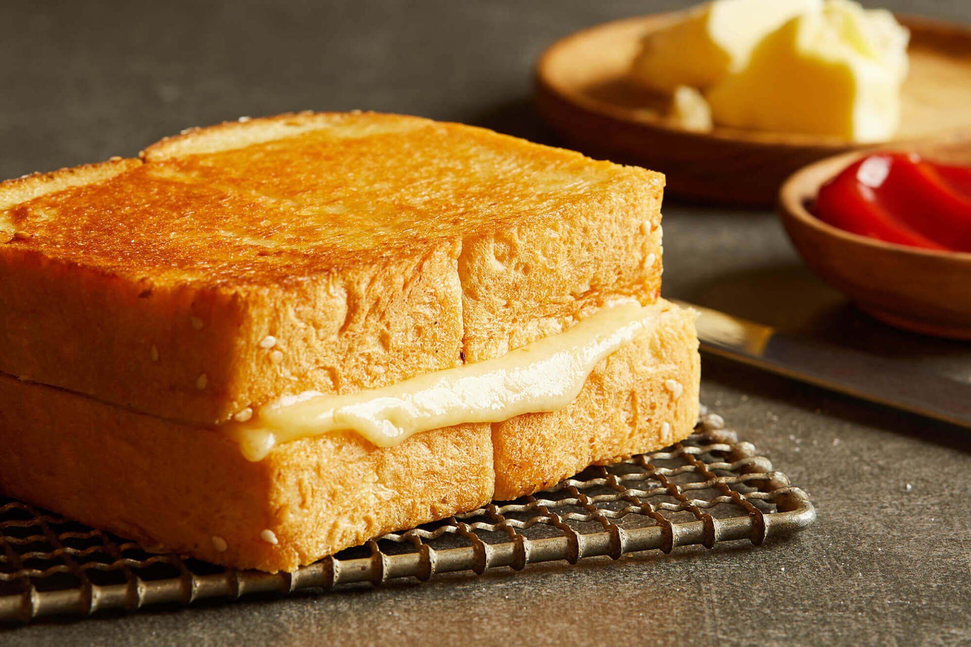 A grilled cheese sandwich is sitting on a cooling rack.