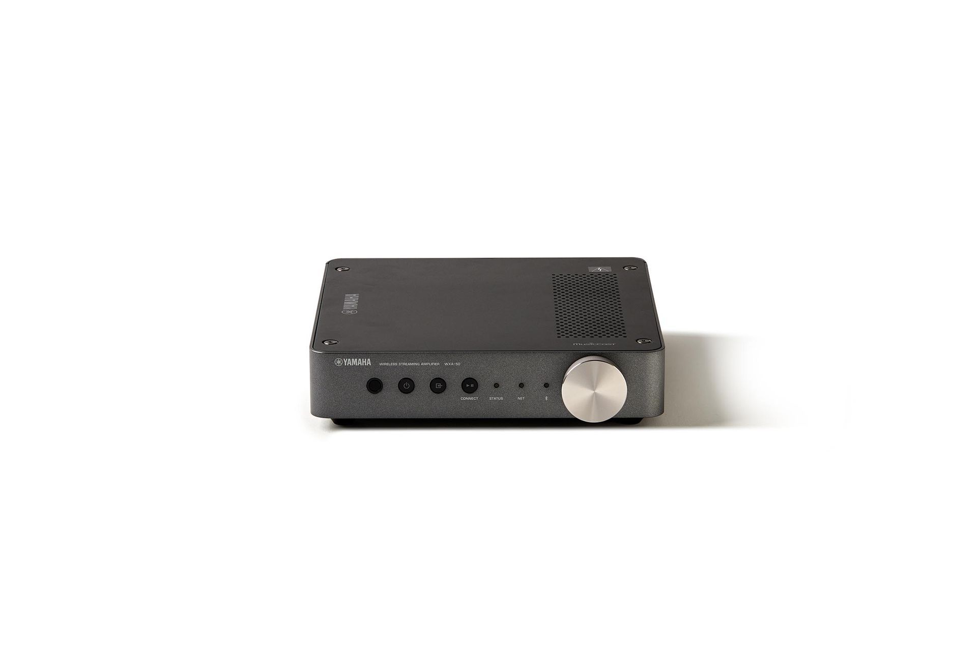 A black amplifier is sitting on a white surface.