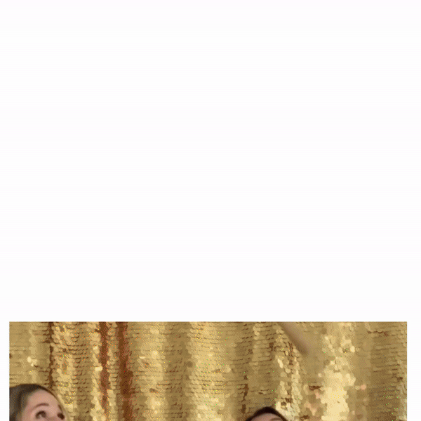 Two women are posing for a picture in front of a gold sequined backdrop.