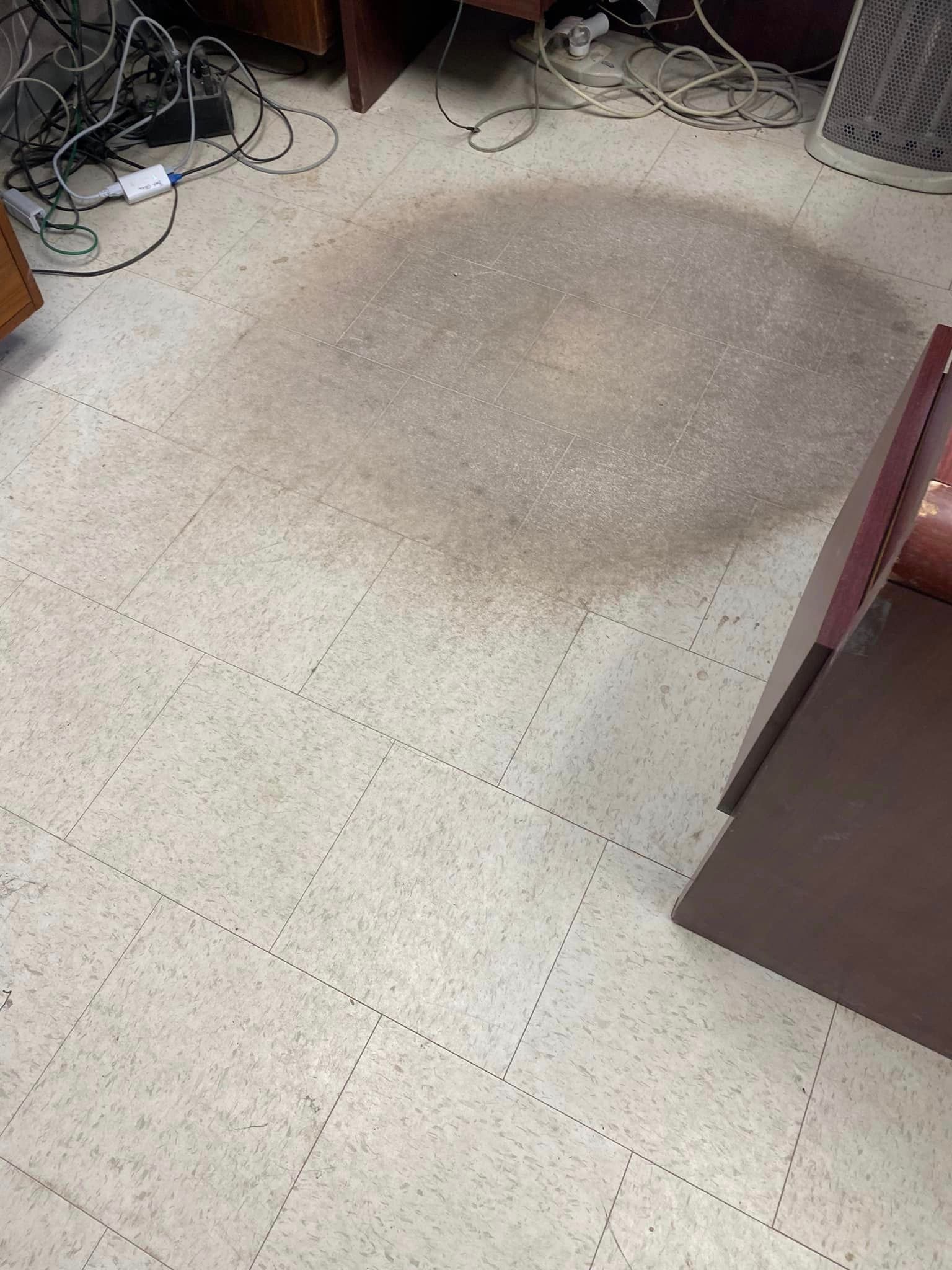 There is a stain on the floor in the middle of the room.