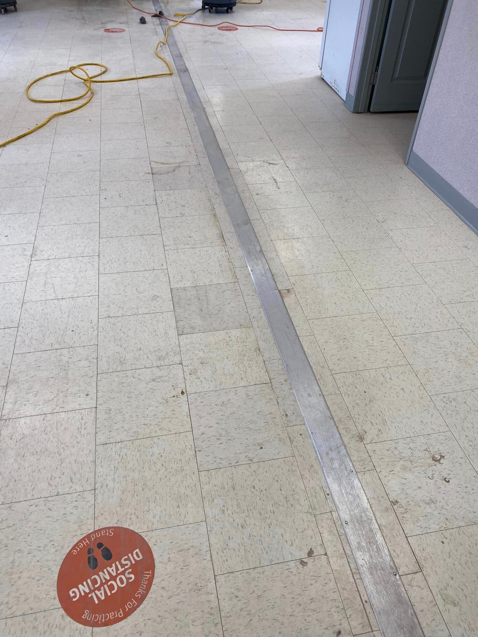 There is a sticker on the floor that says `` social distancing ''.