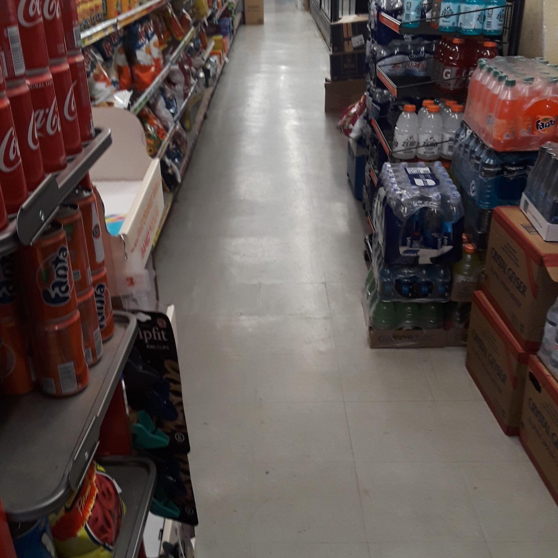 An aisle in a grocery store filled with coca cola and fanta cans