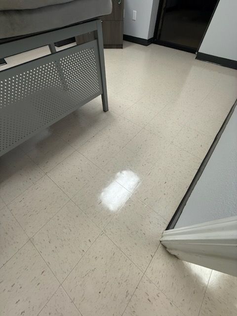 Empty office floor with light-colored carpet, desk, and cabinet edges visible.