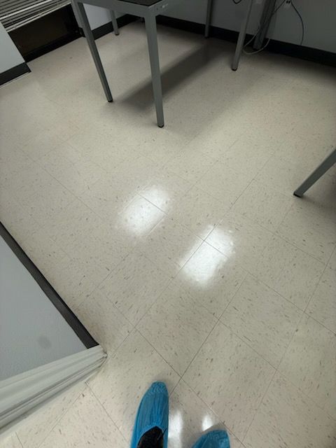 Indoor classroom floor with table legs and a blue shoe visible at the bottom.