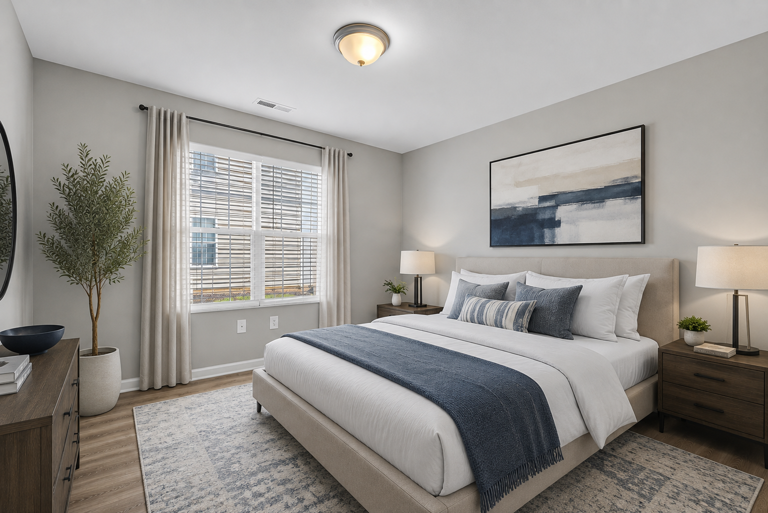 Bright modern bedroom with a bed, nightstands, lamp, window, and framed wall art