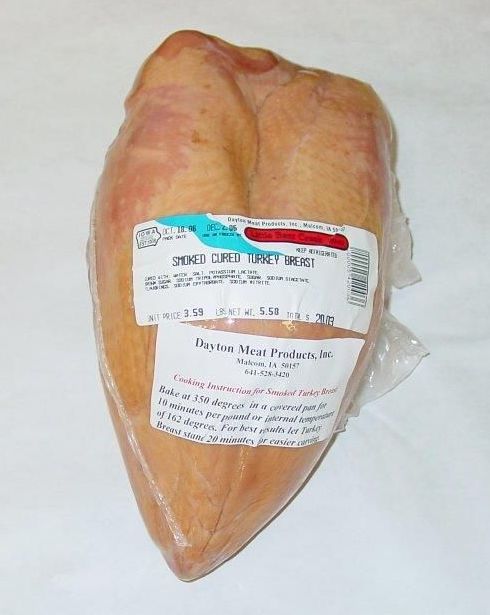 A large piece of meat is wrapped in plastic and has a label on it