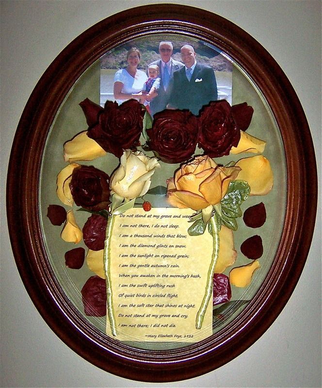 Framed memorial display with dried roses, a photo, and a printed poem on a cream background