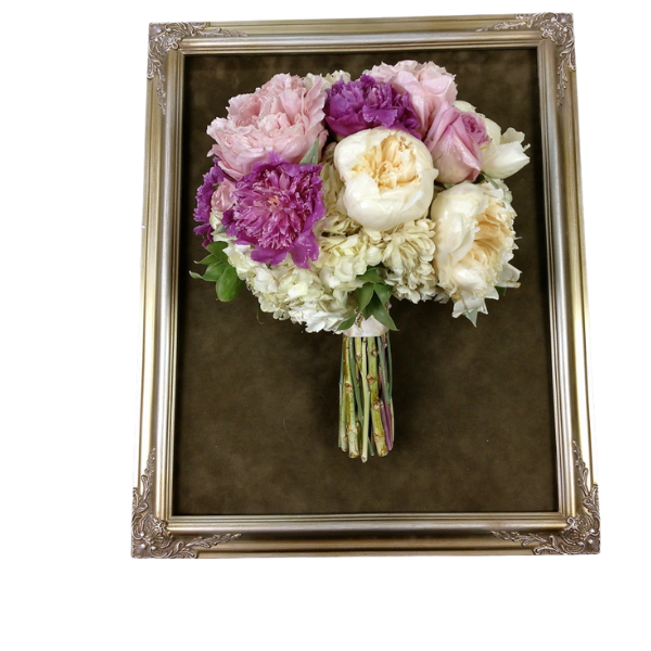 Framed bouquet of pink, purple, and white flowers on a brown background