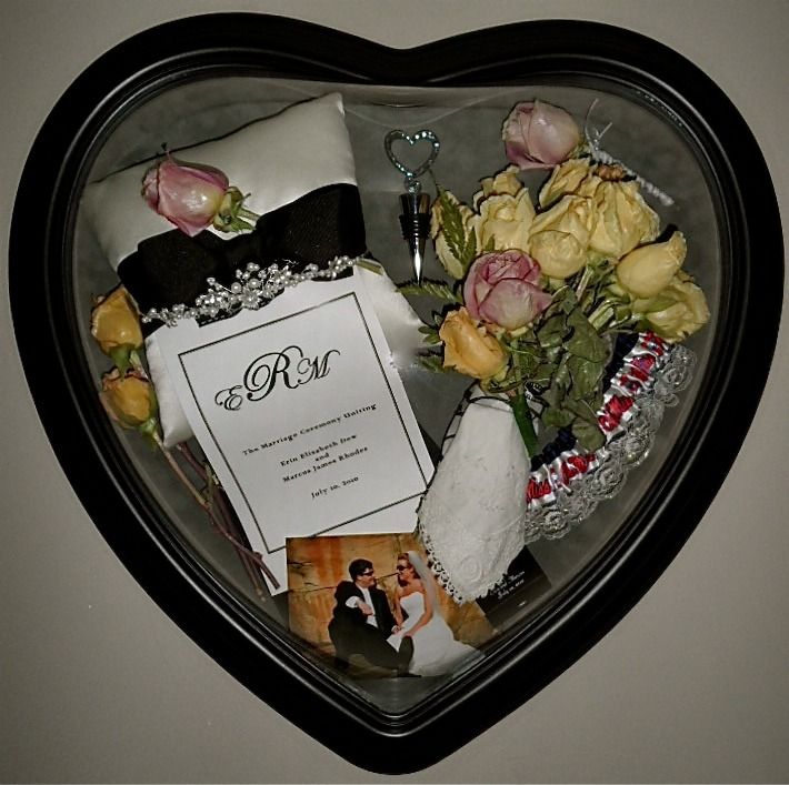 Heart-shaped box with a wedding invitation, roses, ribbon, and a small keychain inside.