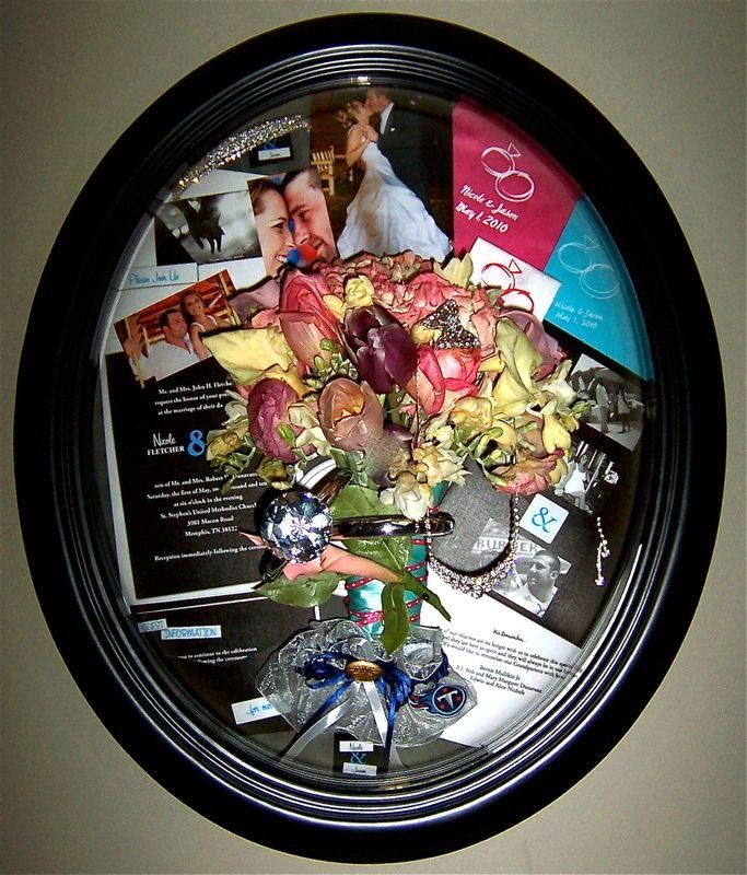 Heart-shaped bouquet of flowers with a gift bag displayed inside a black oval frame
