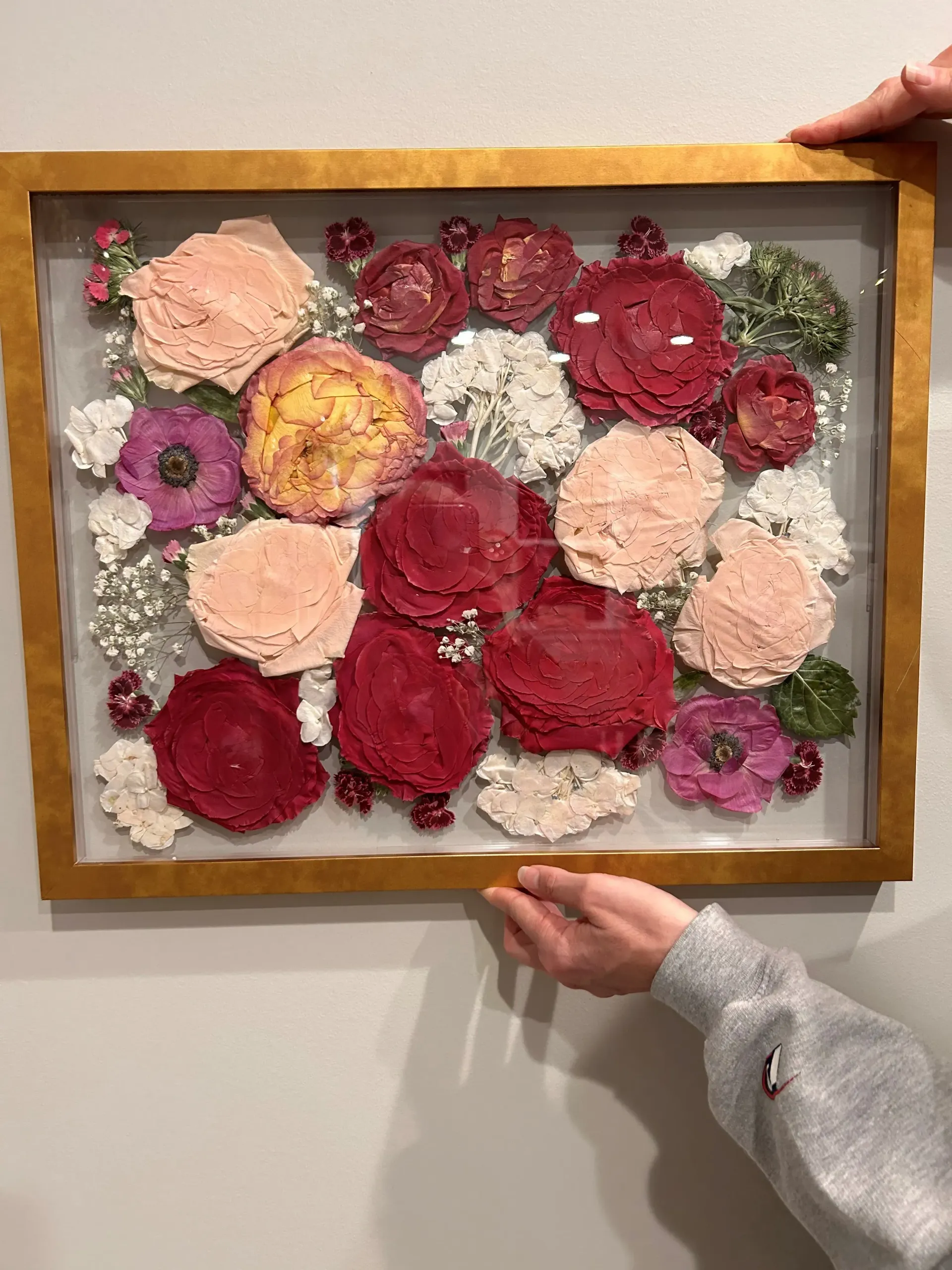 Handcrafted floral wall art in a wooden frame, with pink, red, white, and yellow flowers.