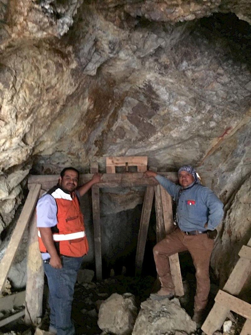 Two men are standing next to each other in a cave.