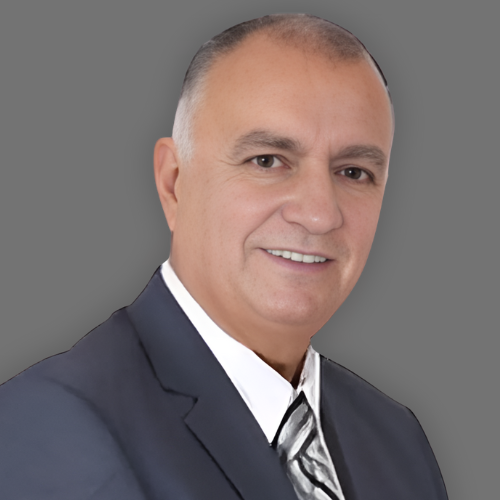 A man in a suit and tie is smiling for the camera