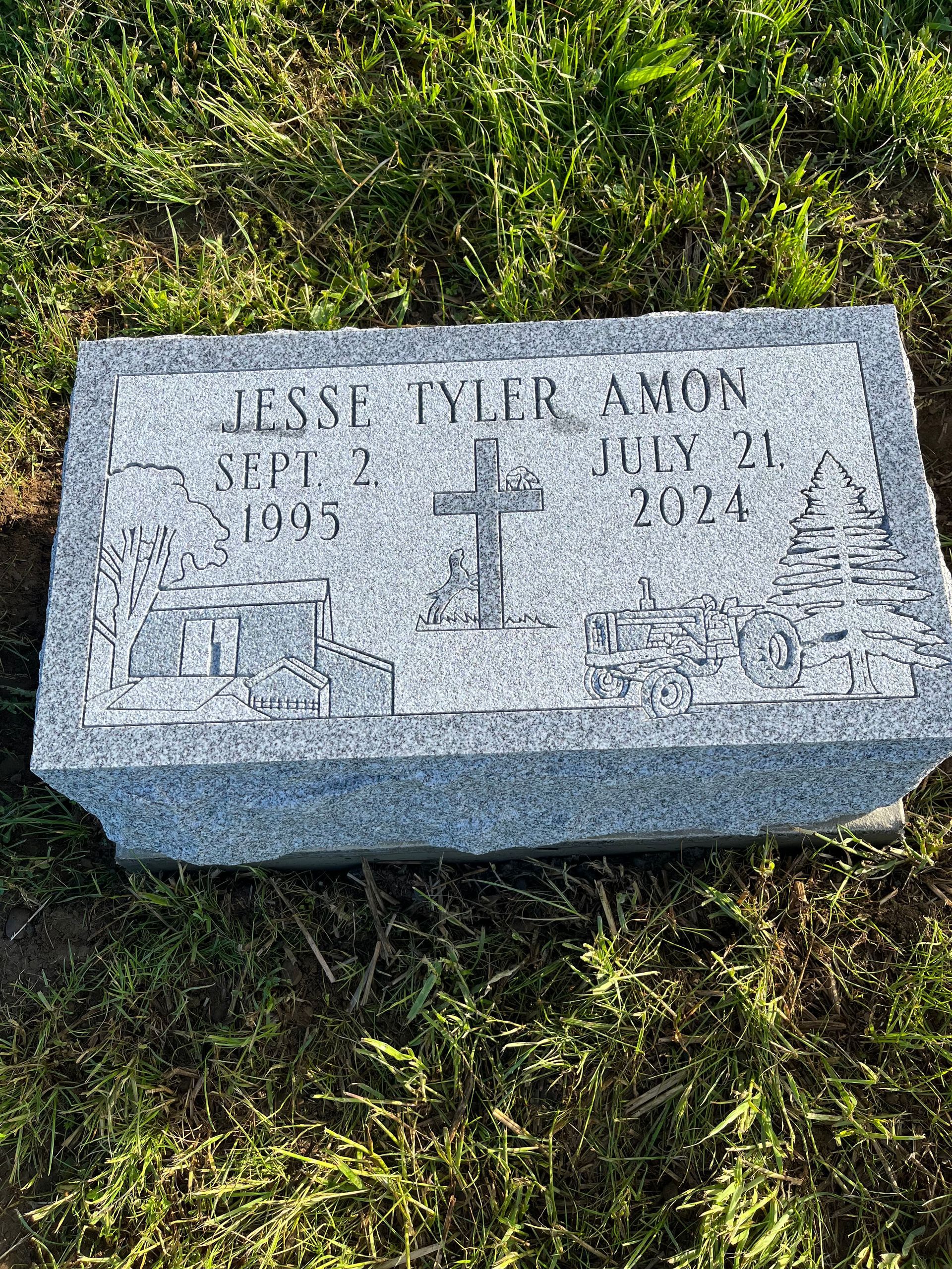 Gray gravestone on grass with a cross and engraved name and dates.