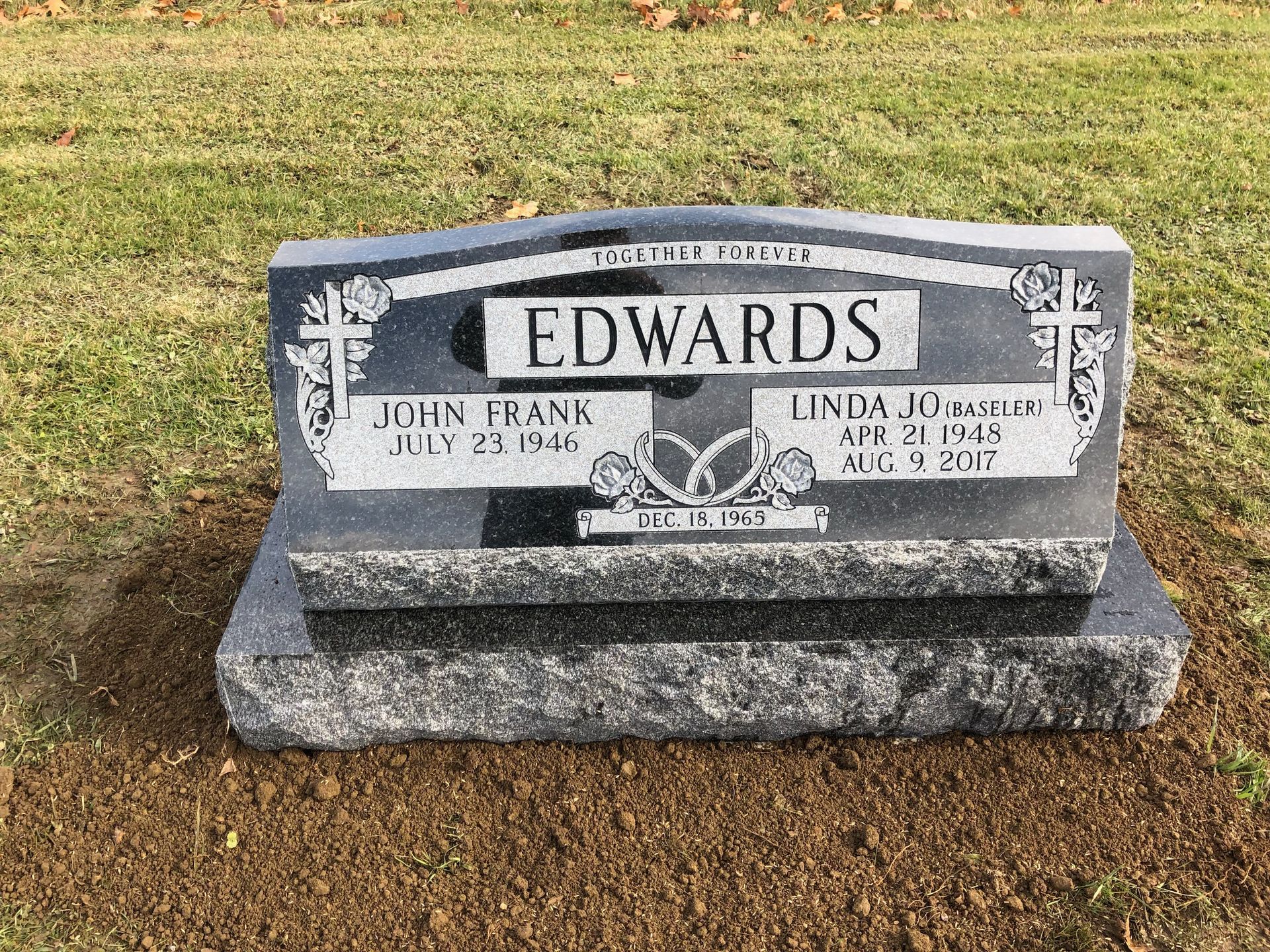 Gray Edwards gravestone in a grassy cemetery, engraved with name and dates.