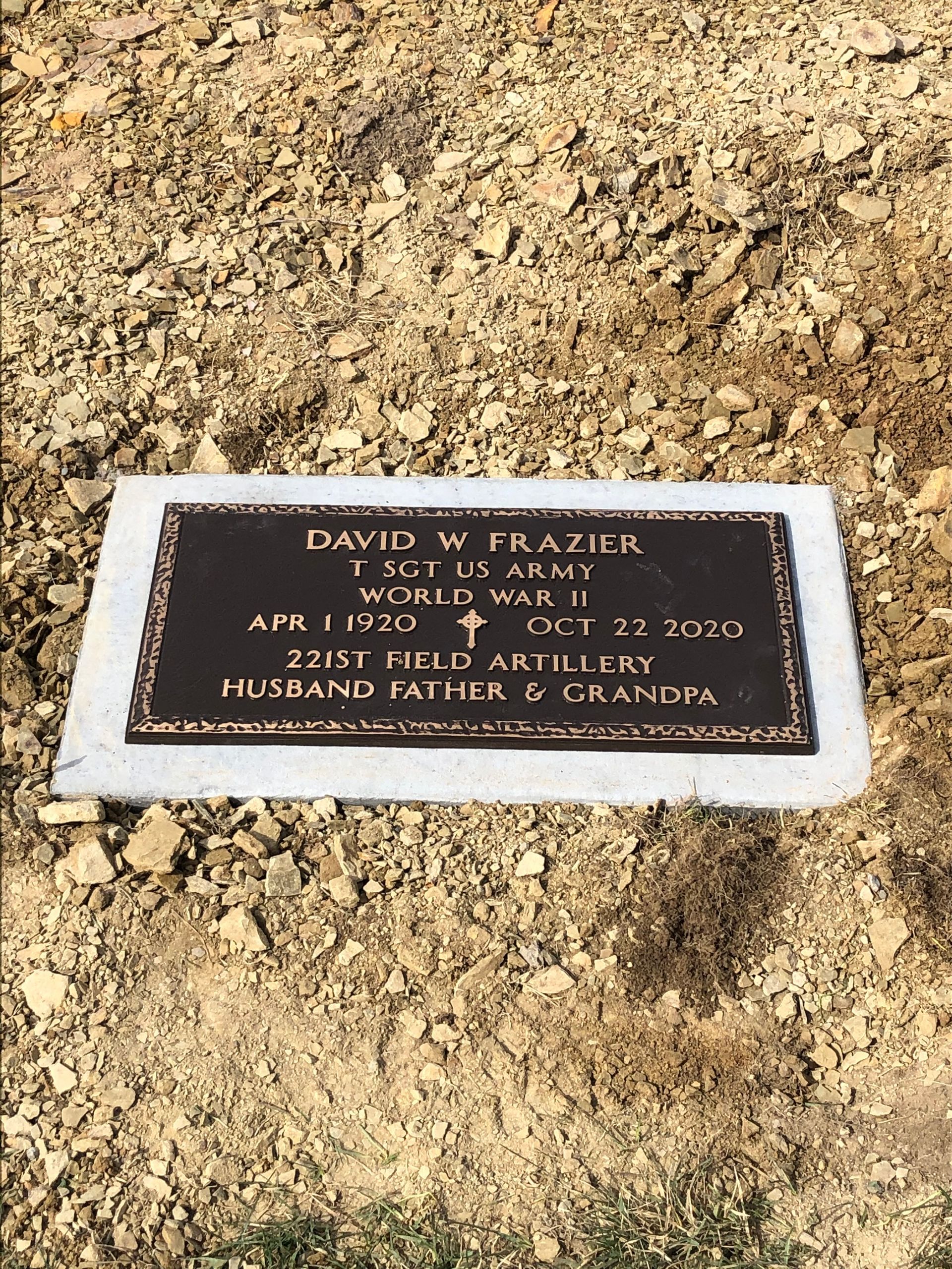 Plaque in rocky ground honoring David W. Frazer, with name and date engraved on dark stone.