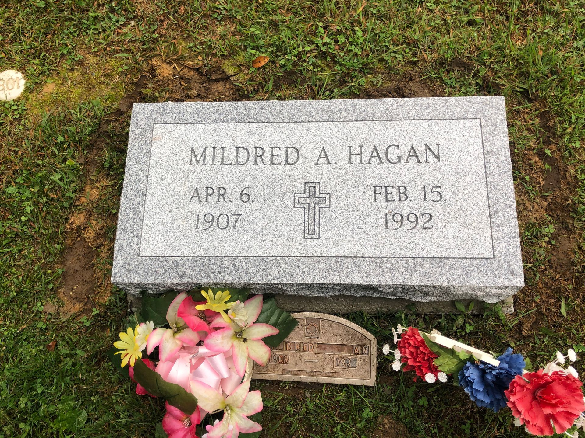 Gravestone with flowers on grass, engraved “Mildred A. Hagan” and dates Apr. 6, 1912–Feb. 13, 1992.