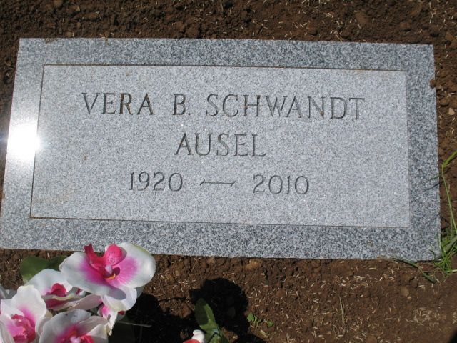 Gravestone engraved “VERA B. SCHWANDT AUSEL, 1920–2010” with flowers at the lower left.