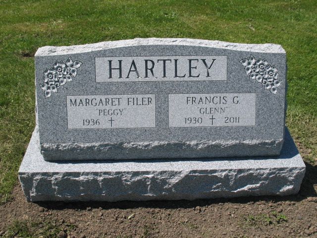 Hartley gravestone with two name plaques in a grassy cemetery