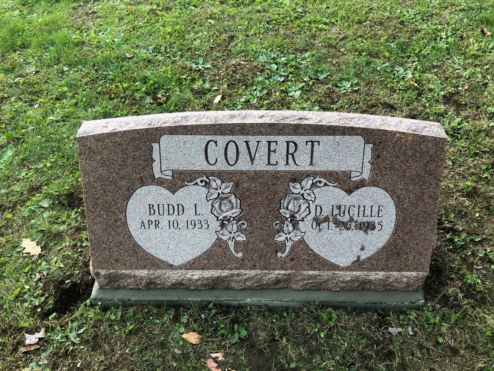 Small brown cemetery headstone marked “COVERT” on a green lawn with faded engraving.