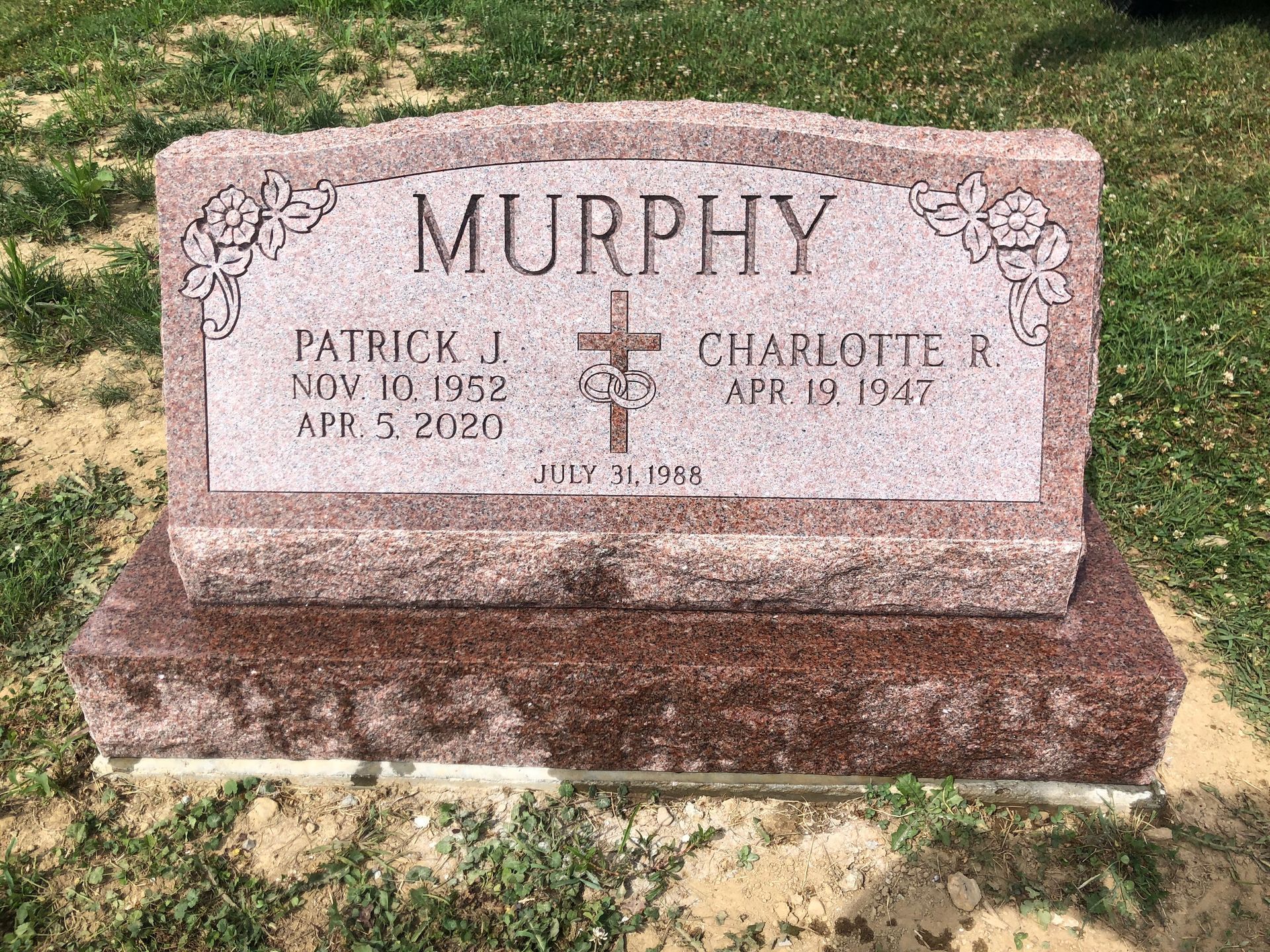Murphy family gravestone in a cemetery, pink granite marker with names and dates.