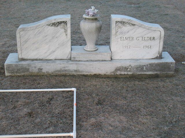 White granite gravestone with a vase centerpiece, engraved “Clark & Elder,” on a grassy cemetery plot.