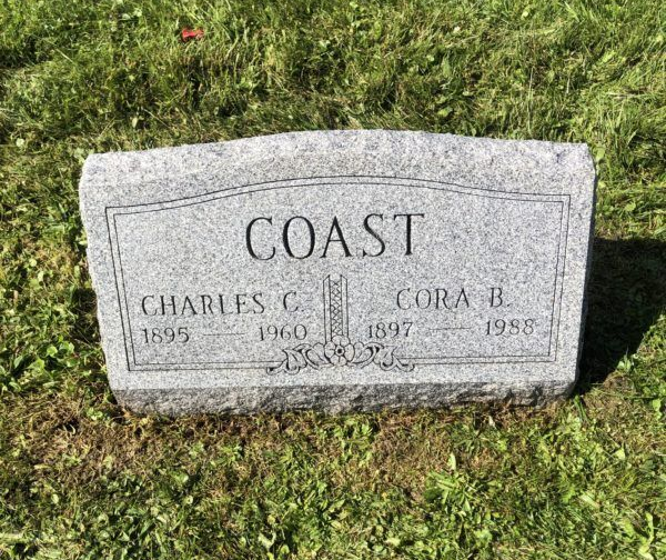 Gray headstone in grass engraved “COAST” with names Charles C. and Cora B.