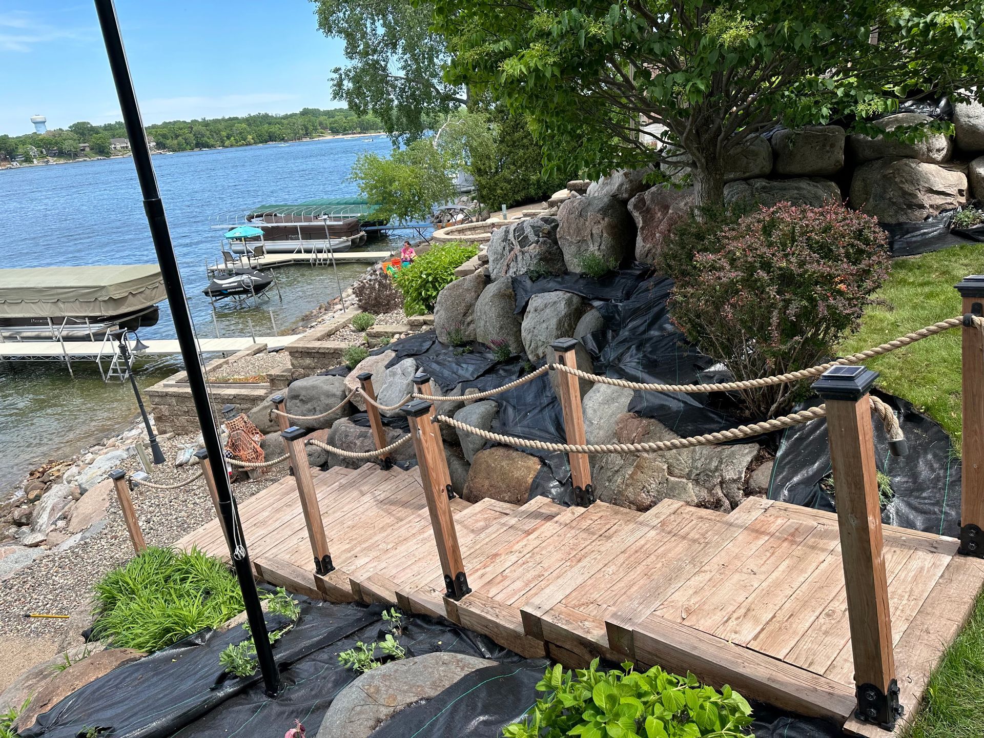 A wooden walkway leading to a lake with a rope fence.