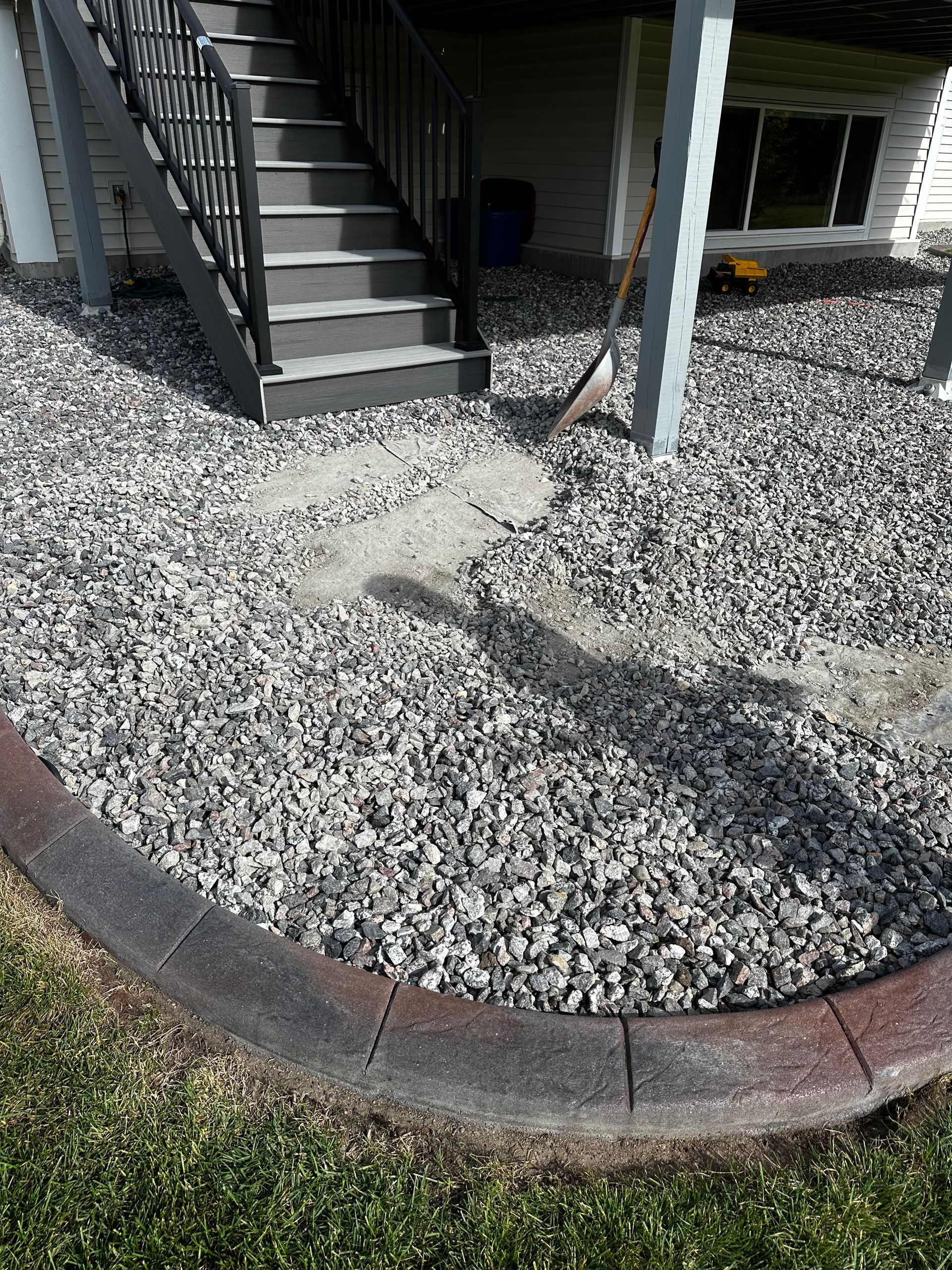 There is a staircase in the background and a pile of gravel in the foreground.