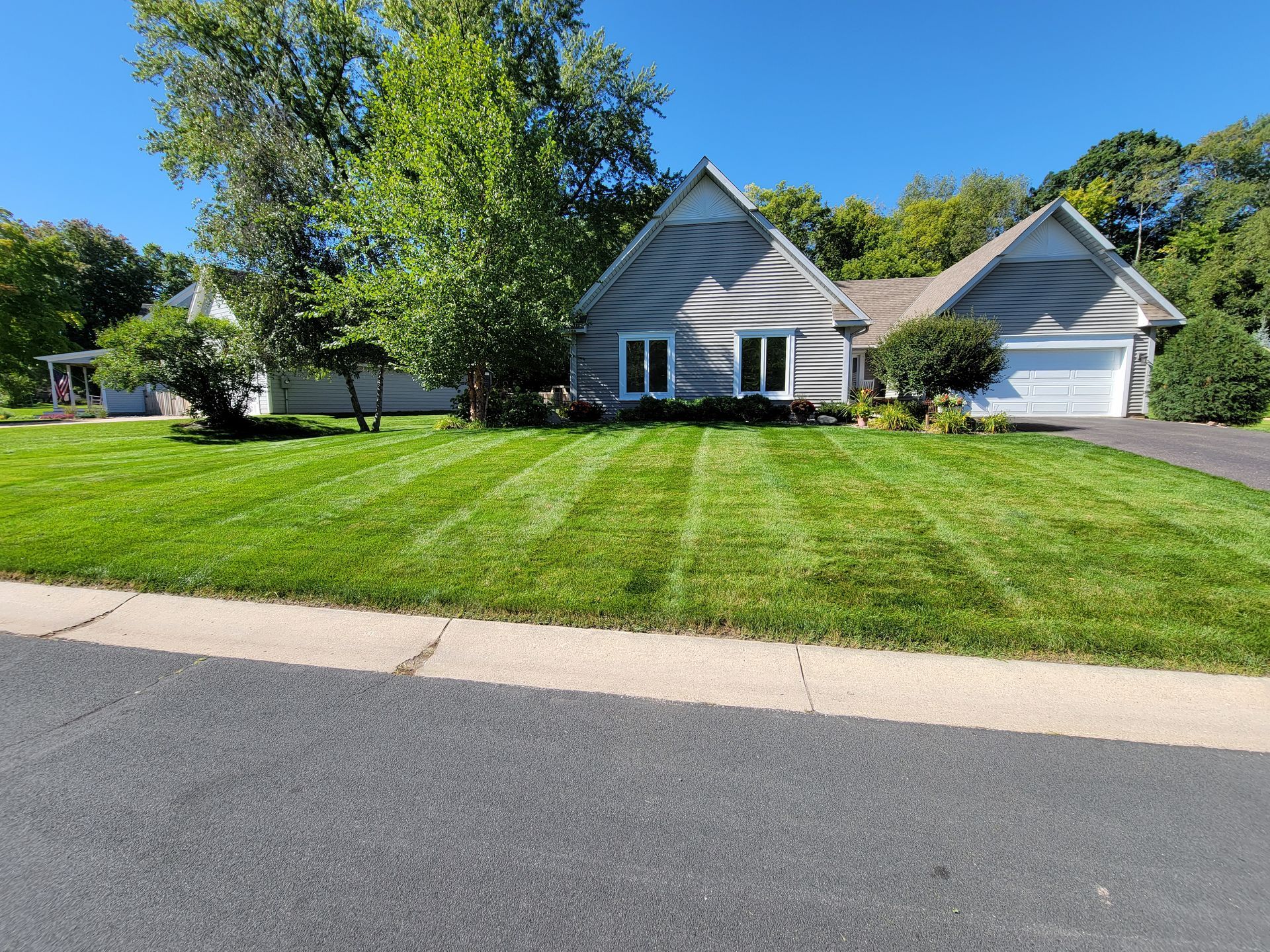 A house with a lush green lawn in front of it.