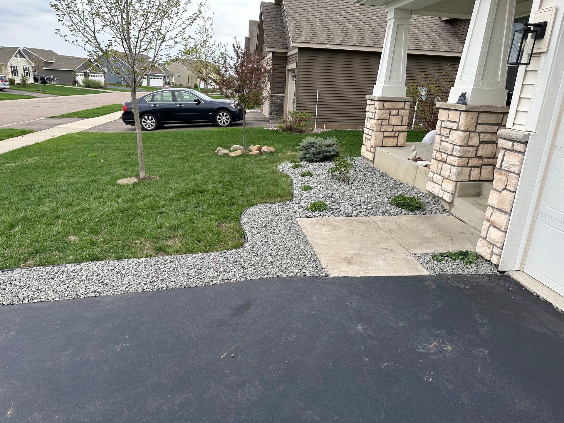 A black car is parked in the driveway of a house.