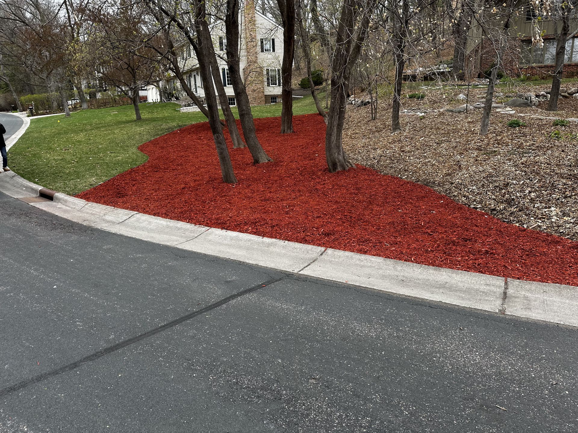 There is a lot of red mulch on the side of the road.