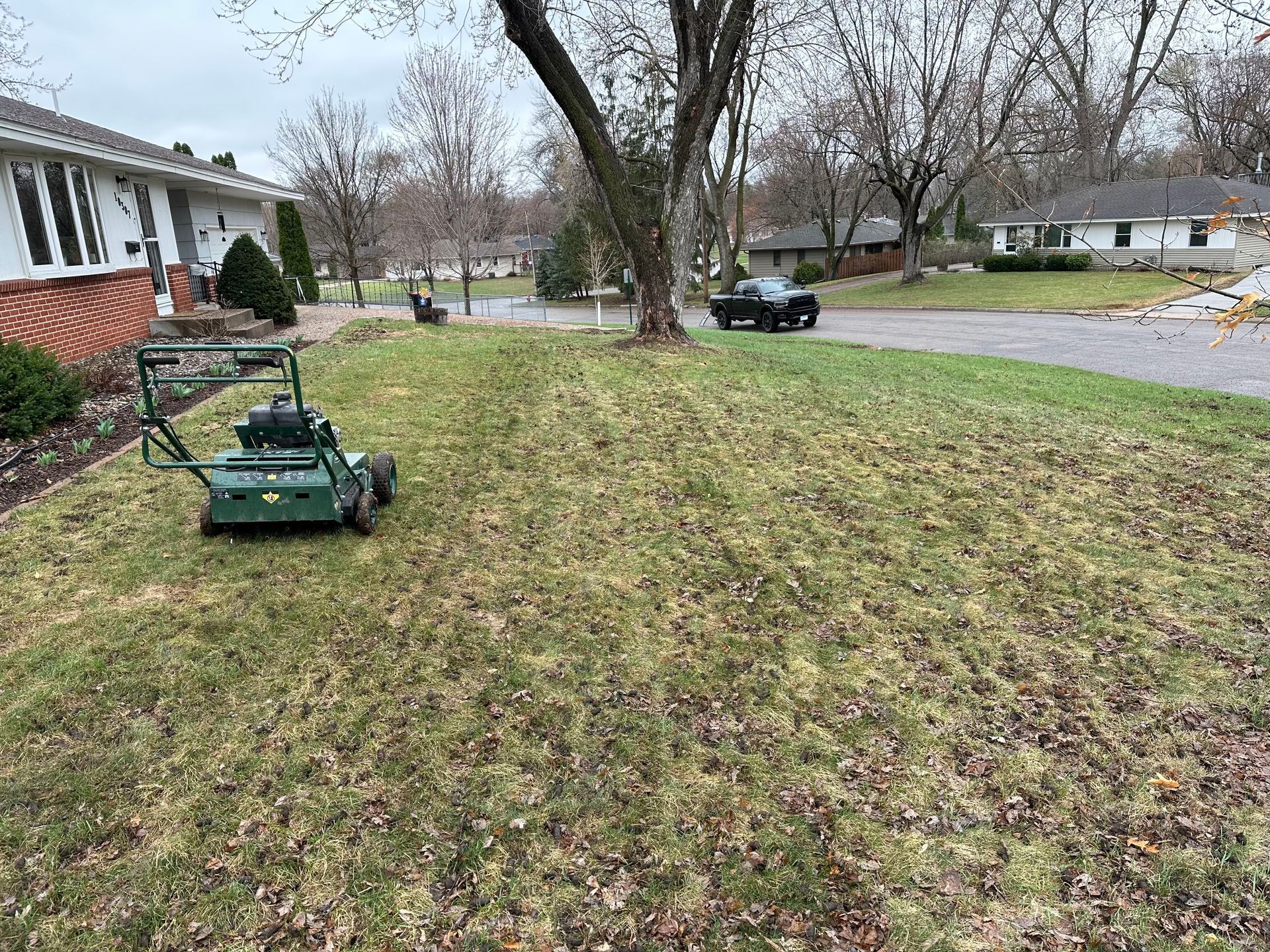 A green lawn mower is sitting in the middle of a lush green lawn.