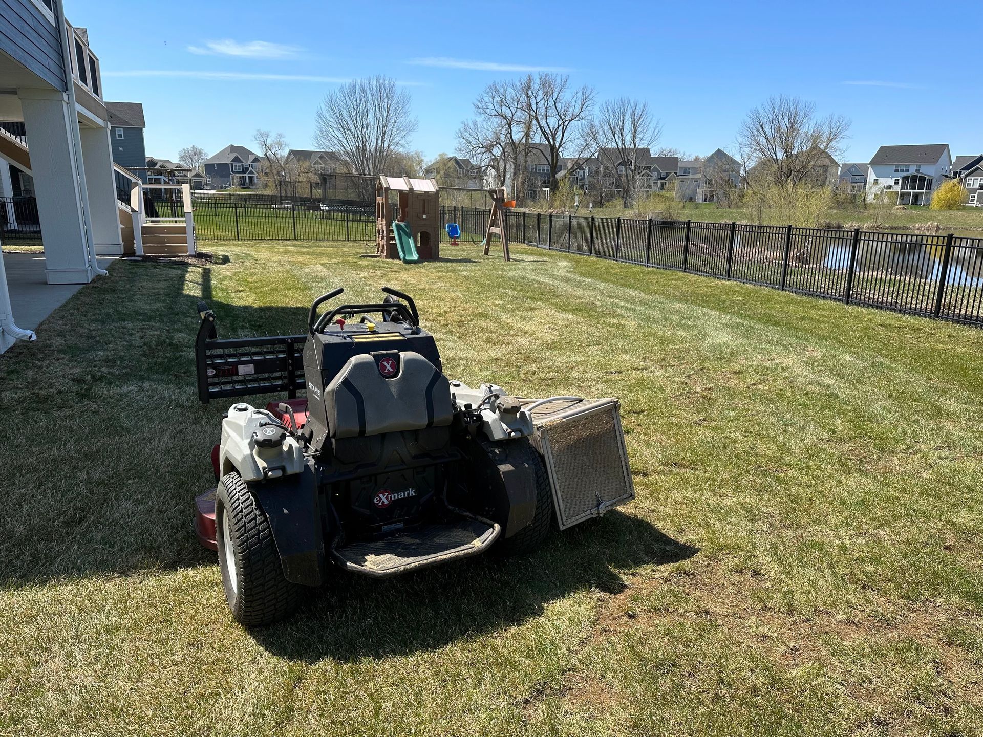 A lawn mower is sitting on top of a lush green lawn.