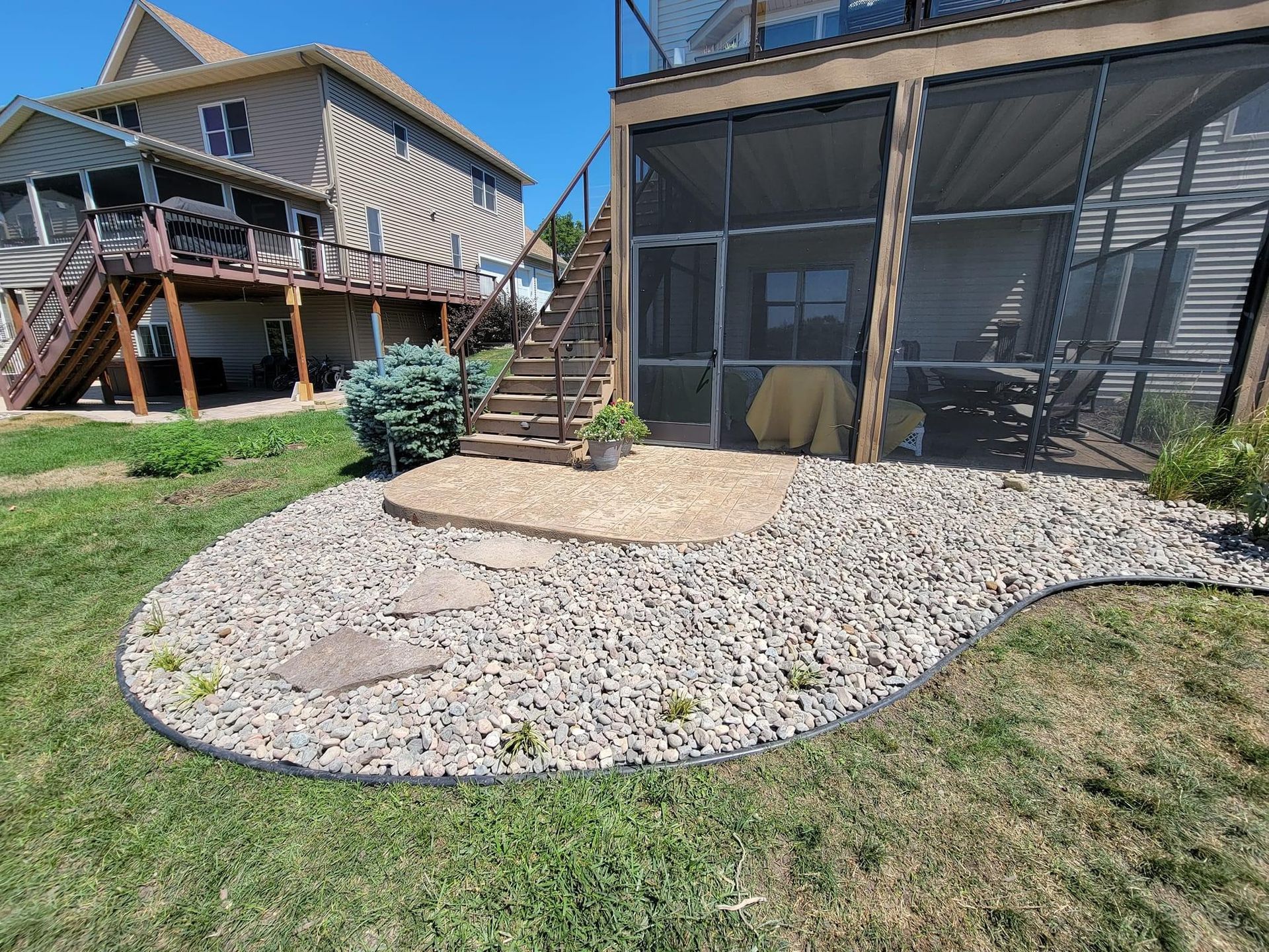 There is a screened in porch in the backyard of a house.