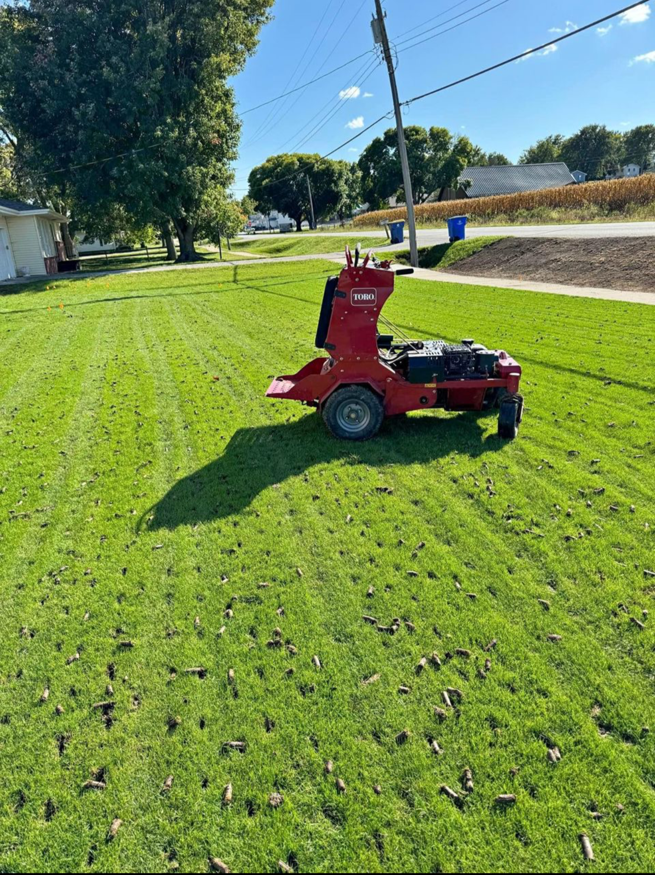 A red lawn mower is sitting on top of a lush green lawn.