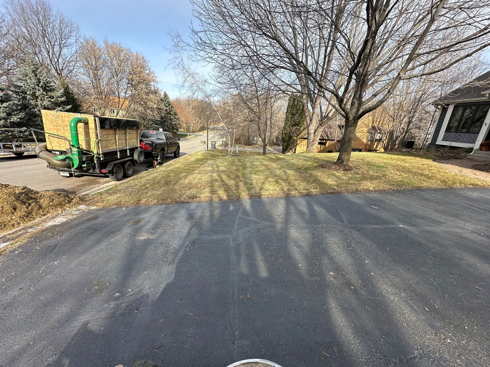 A truck is parked on the side of the road next to a house.