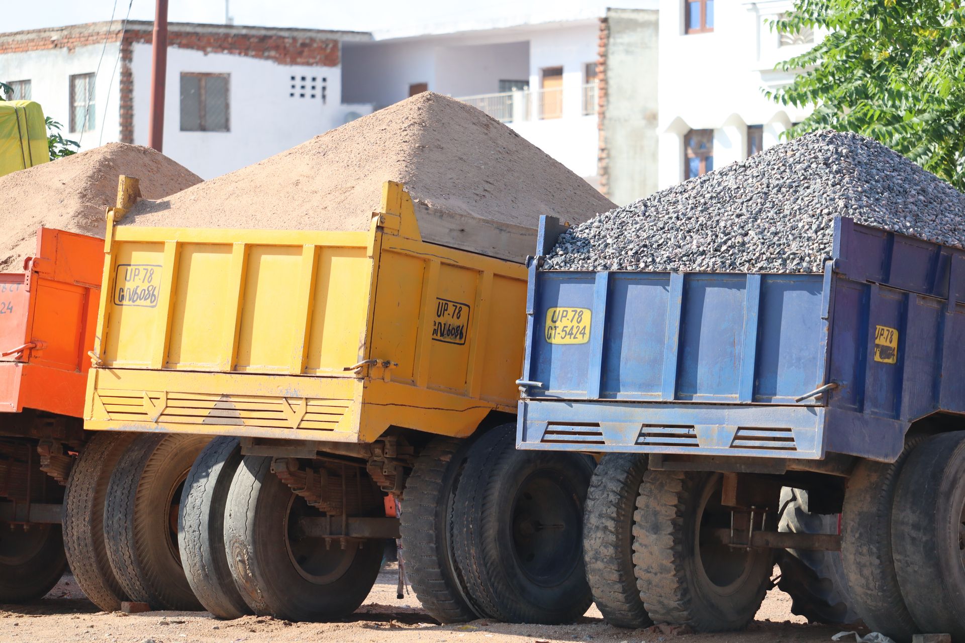 Une rangée de camions à benne basculante sont garés les uns à côté des autres