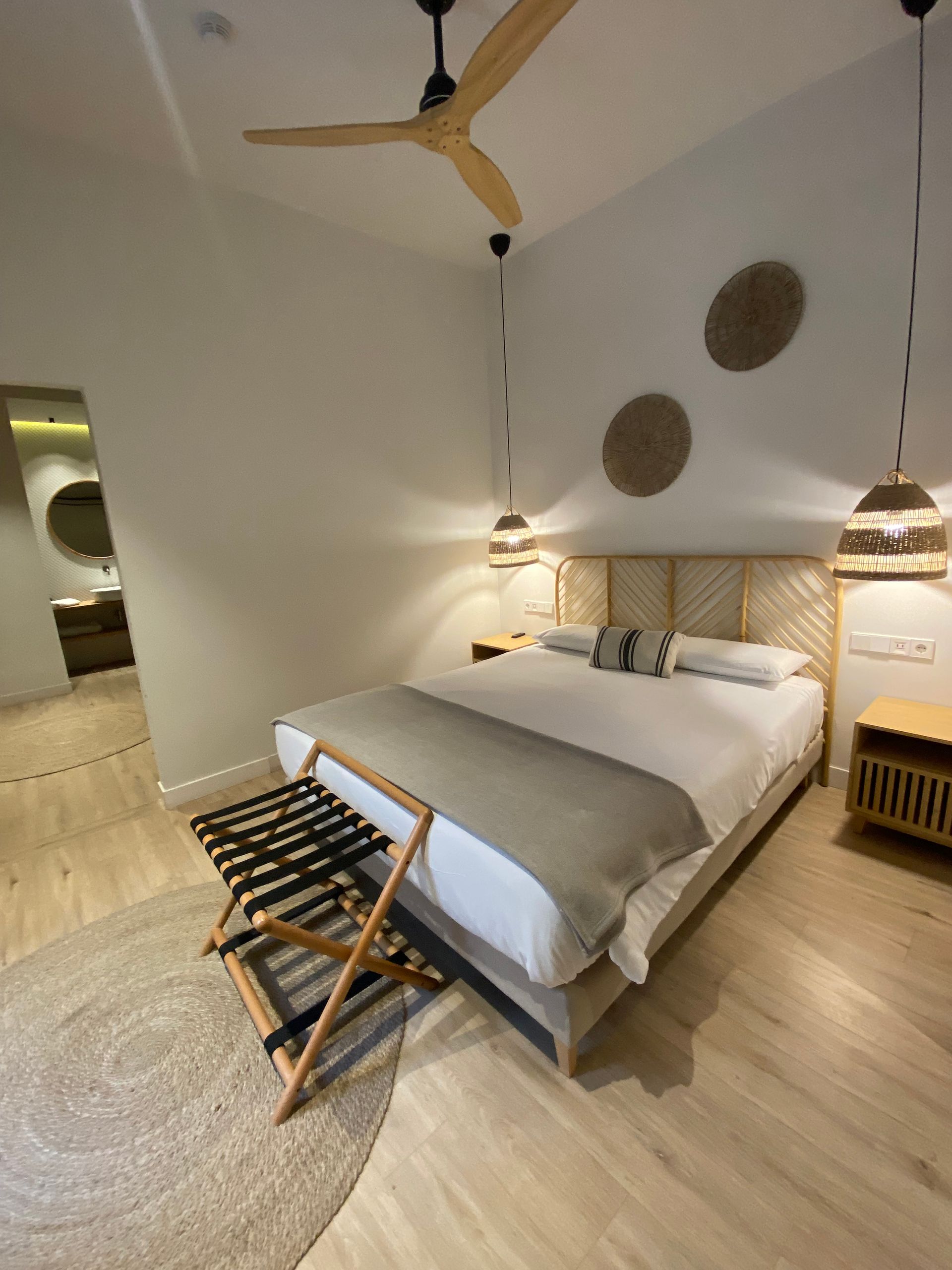 A bedroom with a large bed and a ceiling fan