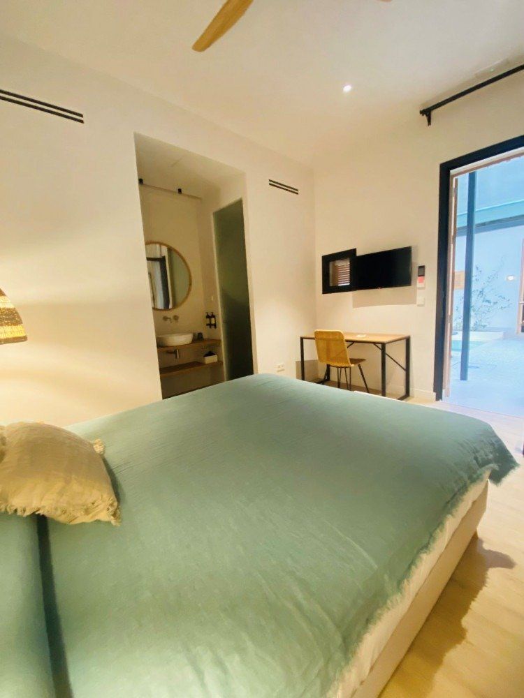 A bedroom with a bed , desk , chair and a ceiling fan.